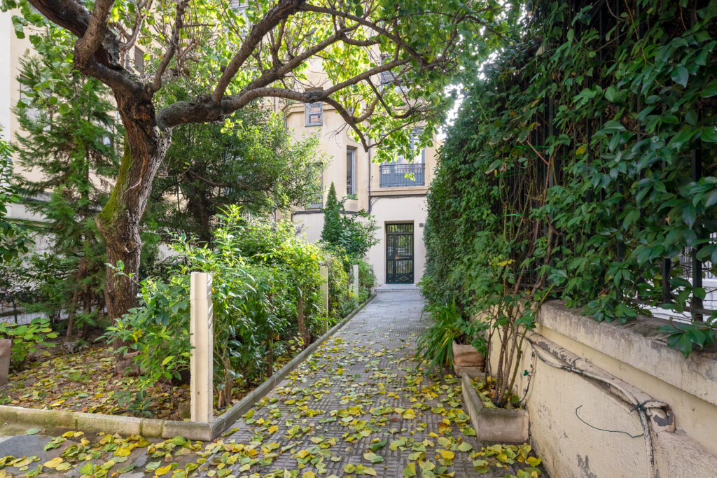 Un patio ajardinado precede al edificio de Viriato n.º 22 y permite el acceso al inmueble. Fotografía de un patio ajardinado precede al edificio de Viriato n.º 22 y permite el acceso al inmueble.